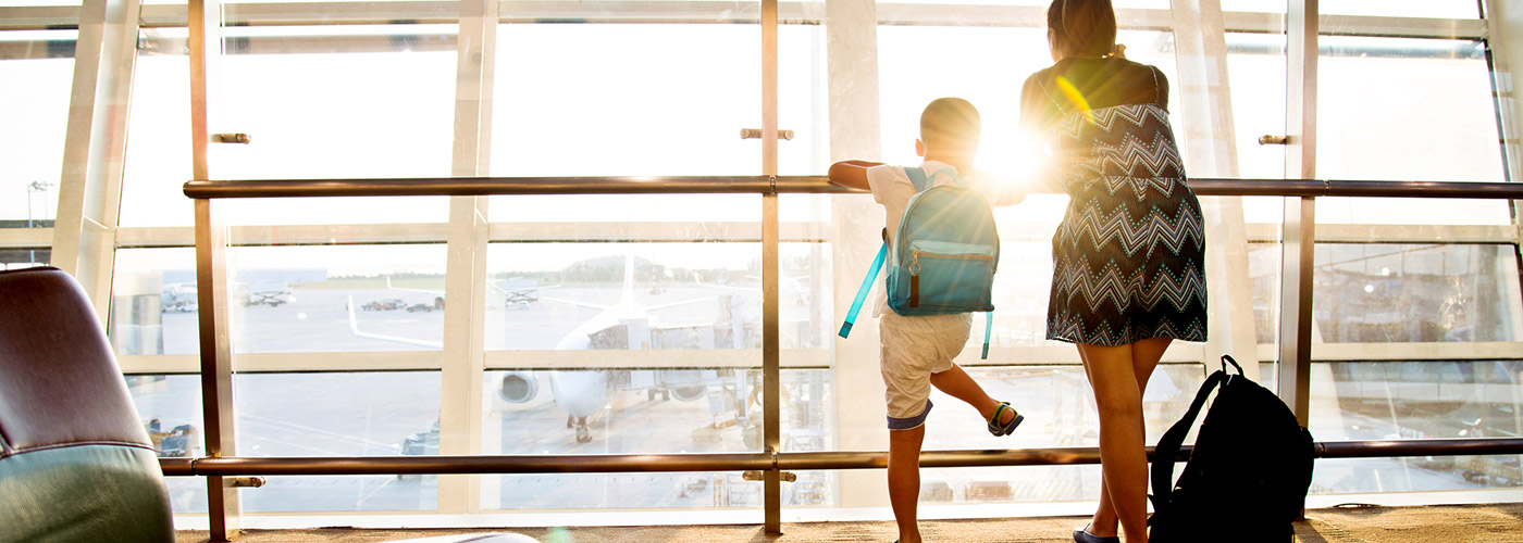 Aeropuerto Una madre y su hijo en el aeropuerto mirando por la ventana a los aviones