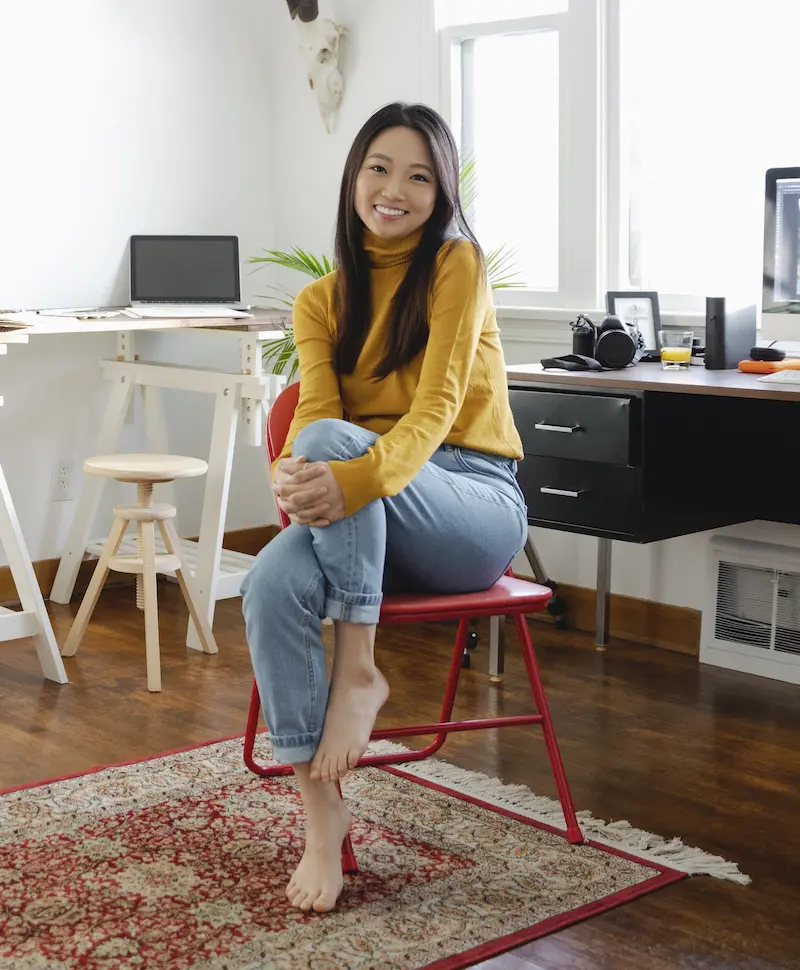 Woman seating on a chair in her apartment and looking at the camera